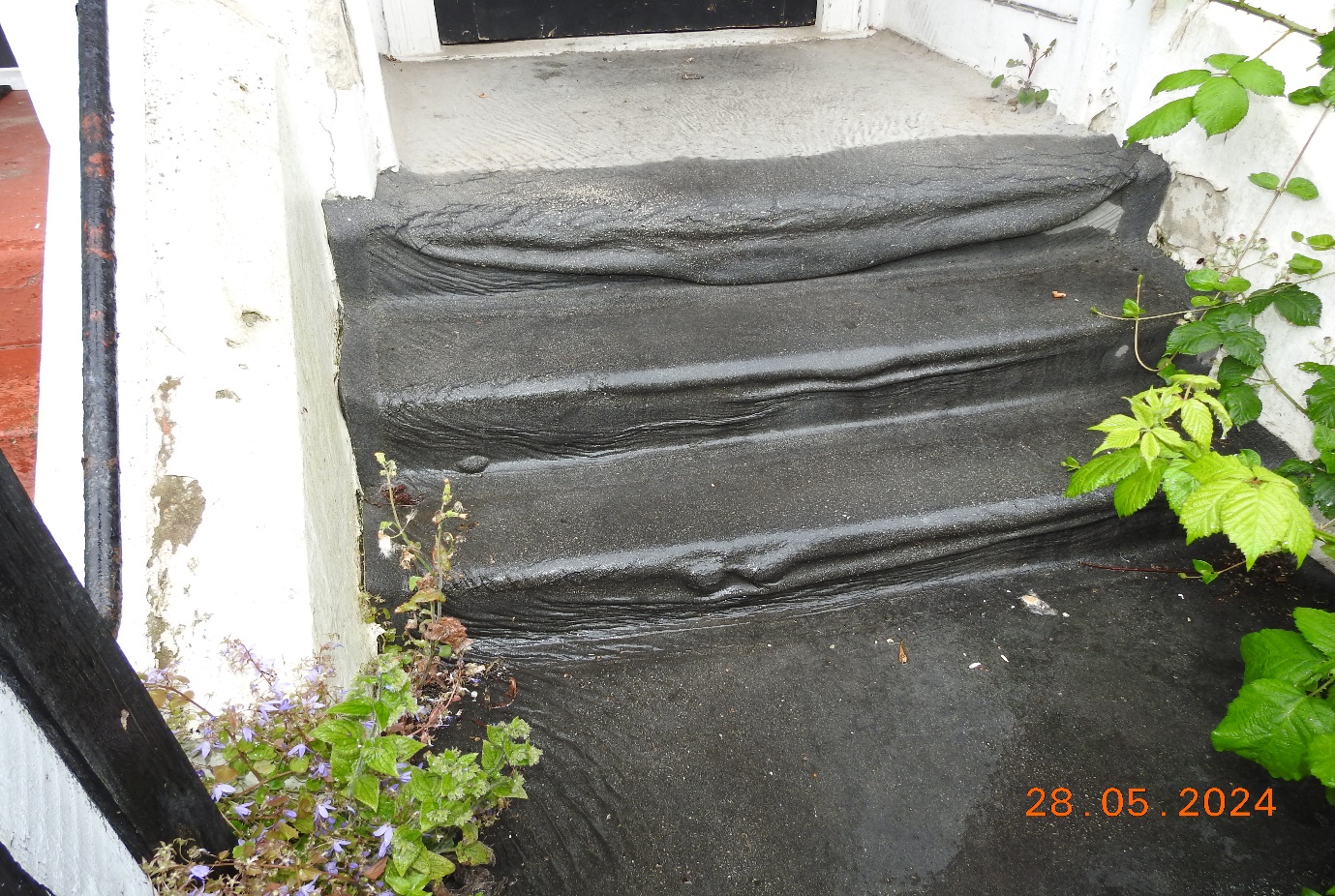 Rolled asphalt to the communal steps, presenting a trip hazard.